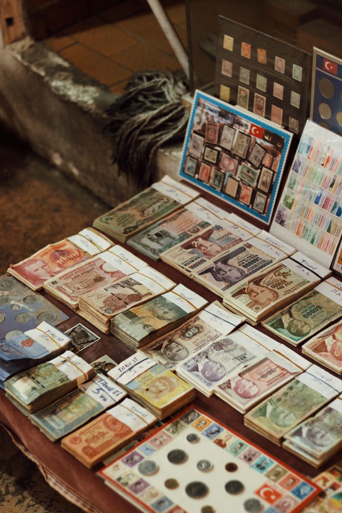 Intriguing close-up of assorted vintage banknotes and coins displayed on a market table.